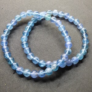 May include: Two blue gemstone bracelets with iridescent beads.