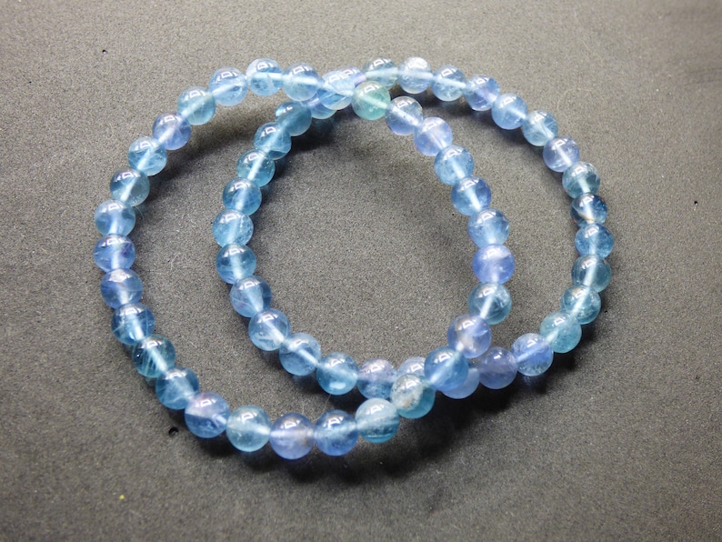 May include: Two blue gemstone bracelets with iridescent beads.