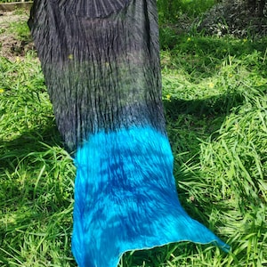 May include: A black and blue silk dance veil with a gradient color effect. The veil is flowing in the wind and is partially covering a green grassy area.
