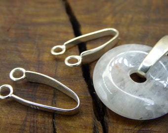 May include: Two silver-toned pendant bails with a round loop on each end. A white, round, flat pendant with a hole in the centre is also shown.