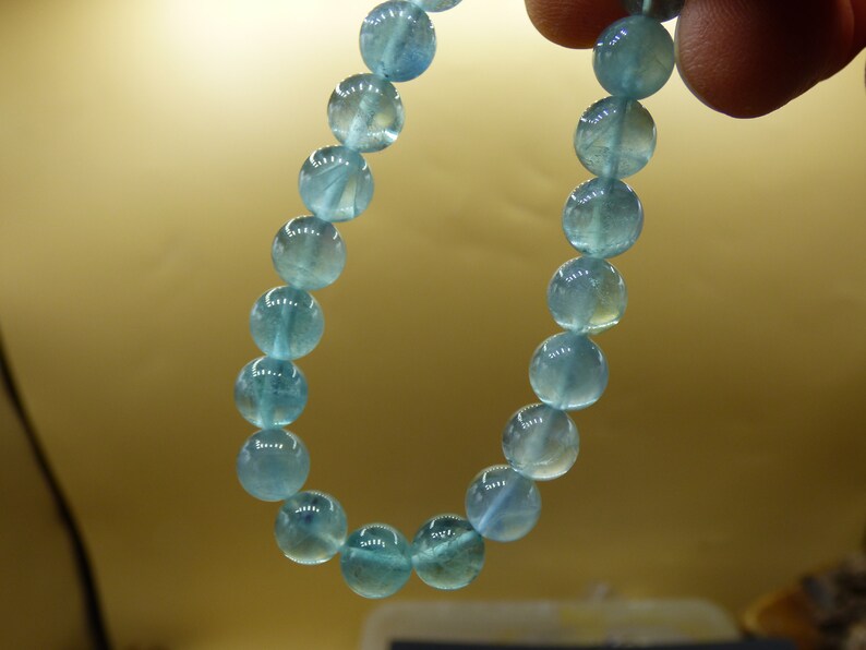 May include: A light blue gemstone bracelet with round beads.
