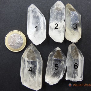 May include: Six clear quartz crystal points, numbered 1 through 6, with a Euro coin for size comparison.