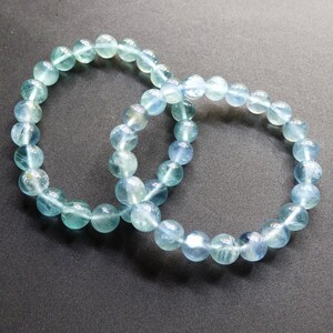 May include: Two light blue gemstone bracelets with round beads.