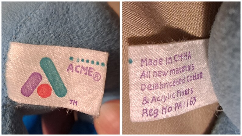 May include: A close-up of two white fabric tags with purple and green text. The first tag shows the logo for ACME with the text "ACME&reg; TM". The second tag reads "Made in CHINA All new materials Delabricated Cotton & Acrylic Fibers Reg No PA1163".