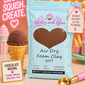 May include: A light blue pouch of Glittz and Glue air dry foam clay in chocolate brown. The packaging features a heart-shaped window, text reading "Air Dry Foam Clay SOFT," and a net weight of 17.6oz (1lb 1.6oz). Includes a tag reading "SO SOFT. SO FLUFFY. SO FUN TO CREATE!"