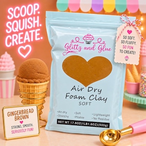 May include: A light blue pouch of Glitz and Glue air dry foam clay in gingerbread brown. The packaging features a heart-shaped window, text reading "Air Dry Foam Clay SOFT," and "NET WT 17.6OZ(1LB 1.6OZ)(500G)." A tag reads "SO SOFT. SO FLUFFY. SO FUN TO CREATE!"