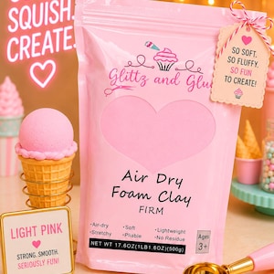 May include: A pink pouch of Glittz and Glue air dry foam clay with a heart cutout. The label reads Air Dry Foam Clay FIRM, Net Wt 17.6oz (1lb 1.6oz) (500g), and Ages 3+. A tag attached reads So Soft. So Fluffy. So Fun To Create! with a cupcake icon.