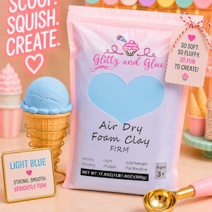 May include: A light blue air dry foam clay package labeled Glitz and Glue with a net weight of 17.6 ounces. The bag features a heart-shaped window, text reading Scoop. Squish. Create., and a tag stating So soft. So fluffy. So fun to create!