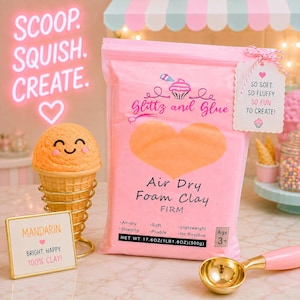 May include: A pink bag of Glitz and Glue Air Dry Foam Clay labeled 17.6 ounces (500g) next to an orange ice cream scoop toy in a gold wire holder, a small sign reading Mandarin, and a gold metal scoop. The bag features a heart and cupcake graphic.