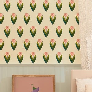 May include: A white wooden toy wagon with a brown teddy bear inside. The wagon has white wheels and a brown handle. The wagon is in front of a white bookshelf with a wicker basket on the bottom shelf. The background is a light yellow wall with a pink and green floral pattern.