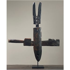 Puede incluir: Una cerradura de puerta de madera con un diseño único. La cerradura está hecha de madera oscura y tiene una base de metal. La cerradura tiene la forma de una cruz con una punta.