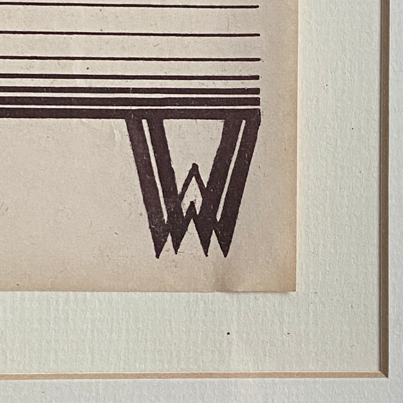May include: A close-up of a black and white illustration of a stylized letter W. The letter is printed on a cream-colored paper.