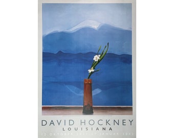 May include: A poster for an exhibition of David Hockney's work at the Louisiana Museum of Modern Art. The poster features a painting of a single white flower in a vase against a blue and white background. The text on the poster reads "David Hockney, Louisiana, 12. Oktober 2001 - 27. Januar 2002."