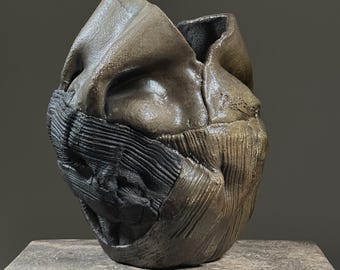 May include: A ceramic sculpture with a textured, abstract design. The sculpture is brown and black and has a rough, organic feel.