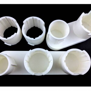 May include: White plastic organizer with six round compartments for storing small items. The organizer is made of a smooth, white plastic and has a simple, modern design.