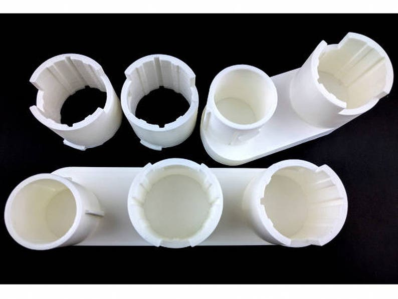 May include: White plastic organizer with six round compartments for storing small items. The organizer is made of a smooth, white plastic and has a simple, modern design.