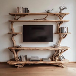 May include: A wooden entertainment unit with a natural, organic design. The shelves are supported by tree-like structures, and hold books, decorative bowls, and a teapot. A large black television is mounted in the centre.