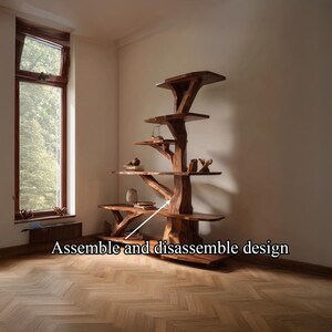 K&ouml;nnte beinhalten: Ein baumf&ouml;rmiges B&uuml;cherregal aus Holz mit mehreren Regalen. Die Regale sind unterschiedlich gro&szlig; und werden von einer zentralen, stammartigen Struktur getragen. Der Text "Assemble and disassemble design" ist unten im Bild zu sehen. Das B&uuml;cherregal befindet sich in einem Raum mit einem Fenster.