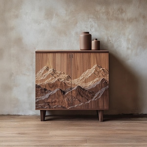 Puede incluir: Un mueble de madera con un diseño de cordillera tallado en las puertas. El mueble es de madera de tonos cálidos y tiene un acabado natural. Dos jarrones de cerámica marrón se encuentran encima. El mueble tiene cuatro patas.