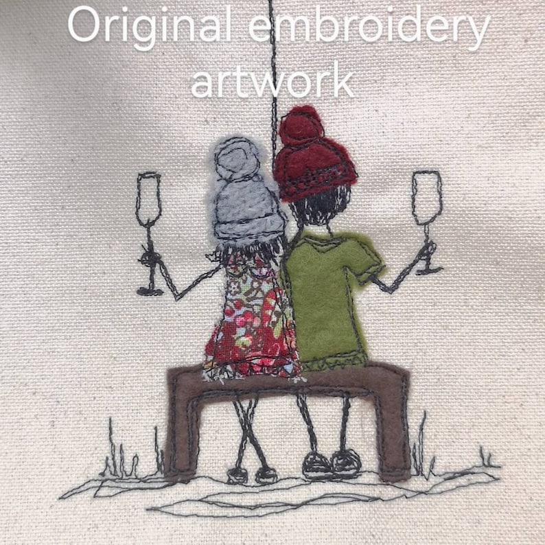 May include: this is the original embroidered artwork depicting two figures seated on a bench, each holding a glass of champagne.