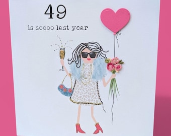 May include: A white greeting card featuring the text 49 is soooo last year. An illustration shows a figure wearing sunglasses, a light blue faux fur stole, and a leopard print dress, holding a gold champagne glass, a blue handbag, and a pink heart balloon.