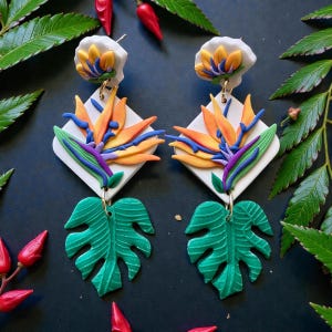 Handgemaakte polymeerklei paradijsvogeloorbellen met monsterablad