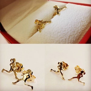 Puede incluir: Un par de pendientes de oro con un diseño de corredor. Los pendientes están hechos de metal dorado brillante y tienen un cierre de poste.