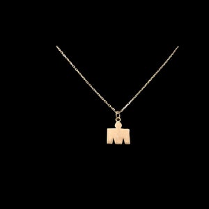 May include: A gold chain necklace with a pendant shaped like a stylized person. The pendant is a simple silhouette of a person with a head and arms.