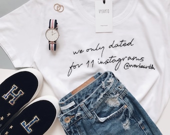 May include: White t-shirt with black text that reads "we only dated for 11 instagrams @overheardla". A pair of black velvet slip-on shoes with gold stars and a gold letter "H" on each shoe. A pair of blue jeans with distressed details.