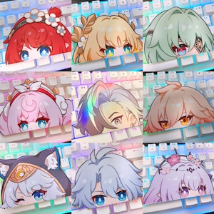 May include: Nine colorful anime-style character stickers, each featuring a unique hairstyle and eye color, peeking over a white keyboard. The stickers have various floral and decorative headbands.