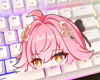 Puede incluir: Un personaje de anime rosa con cabello largo y ojos grandes. El personaje lleva una diadema dorada con un diseño de mariposa. El personaje está en un teclado blanco con teclas negras.