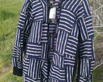 Op de afbeelding: Een blauw-wit gestreept hooded jack met een zwarte rand en meerdere gespen aan de voorkant.