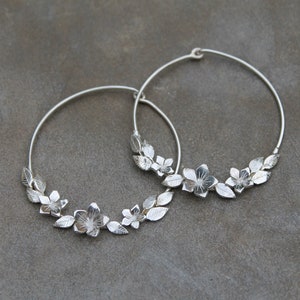 Silver hoop earrings with minimalist flowers and leaves