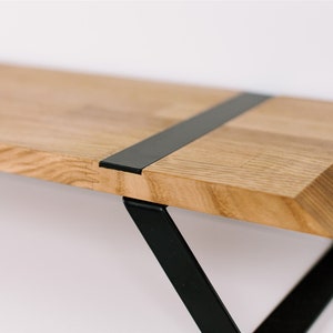 May include: A wooden shelf with a black metal bracket. The shelf has a black metal strip running across the top.