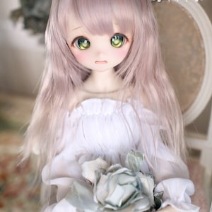 May include: A doll with long, wavy, light pink hair, wearing a white off-the-shoulder dress and holding a large, light blue fabric rose.