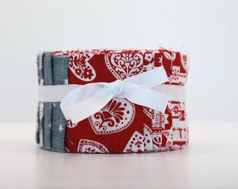 Scandi Christmas Quilt Roll 23. 26 strips of printed fabrics in shades of red, gray and ecru. Christmas jelly roll