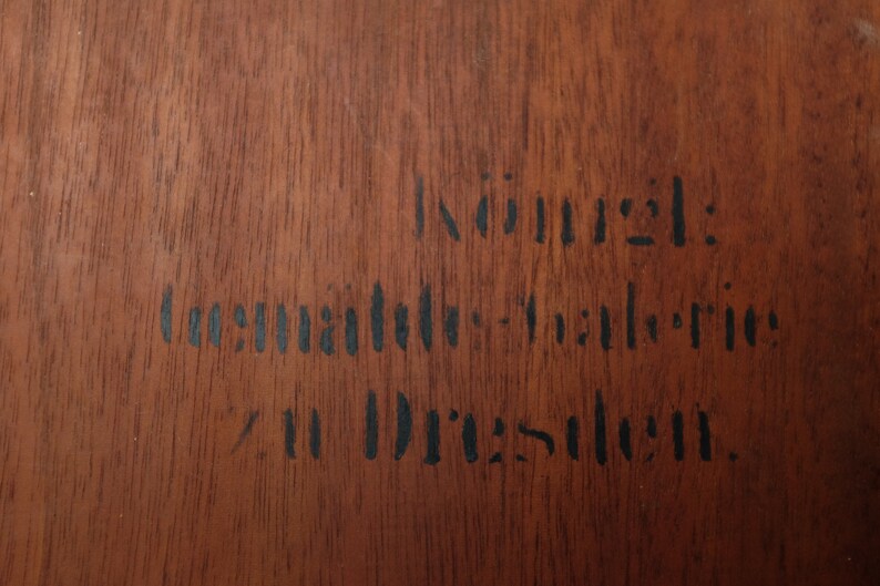May include: A close-up of a wooden surface with black ink stamped text that reads "Innung:  Deutsche  Industrie  in Dresden."
