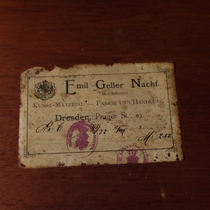 May include: A vintage label with the text "Emil Geller Nachf. Hoflieferant KUNST-MATERIAL FABRIK UND HANDLUNG Dresden, Prager St: 19.  Av: 6 37 M: 2.50"