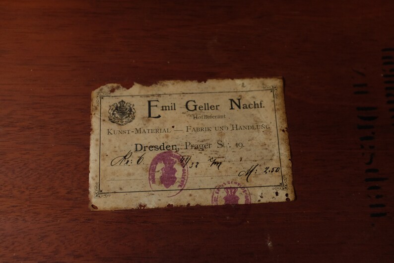 May include: A vintage label with the text "Emil Geller Nachf. Hoflieferant KUNST-MATERIAL FABRIK UND HANDLUNG Dresden, Prager St: 19.  Av: 6 37 M: 2.50"