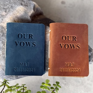 Puede incluir: Dos diarios encuadernados en cuero con el texto "Our Vows" grabado en la portada. Los diarios son azul y marrón y tienen la fecha "09/16/2024" y las iniciales "M&J" grabadas en la portada.