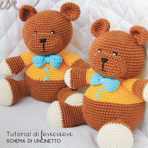 Può includere: Due orsacchiotti di peluche marroni all'uncinetto che indossano camicie gialle con papillon blu. Gli orsacchiotti sono seduti su una superficie a strisce bianche e marroni. Il testo "Tutorial di fare creare SCHEMA DI UNCINETTO" è visibile nella parte inferiore dell'immagine.