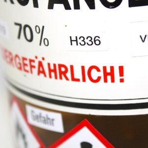 Puede incluir: Una botella de vidrio marr&oacute;n con una etiqueta blanca que dice "70% GEF&Auml;HRLICH!" y "H336" y "VbFB".