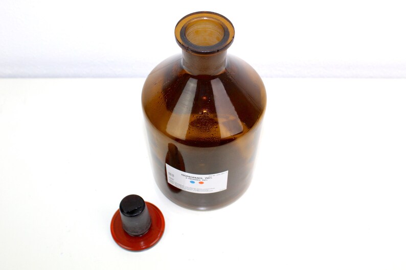 Puede incluir: Una botella de vidrio marr&oacute;n con una tapa negra y una etiqueta blanca que dice "&Aacute;CIDO CLORH&Iacute;DRICO 37%".