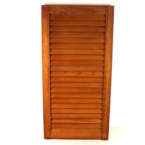 Puede incluir: Una persiana de madera con lamas horizontales de color marrón claro. La persiana está cerrada y tiene un diseño sencillo.