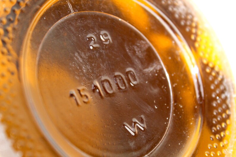Puede incluir: Primer plano de una botella de vidrio marr&oacute;n con una etiqueta que dice "29 151000 W".