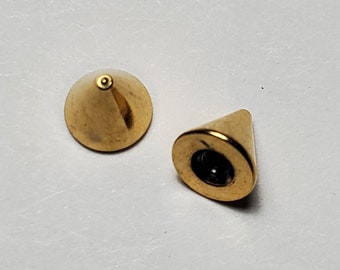 Op de afbeelding: Twee goudkleurige metalen piramidevormige studs. De studs hebben een puntige bovenkant en een platte basis.