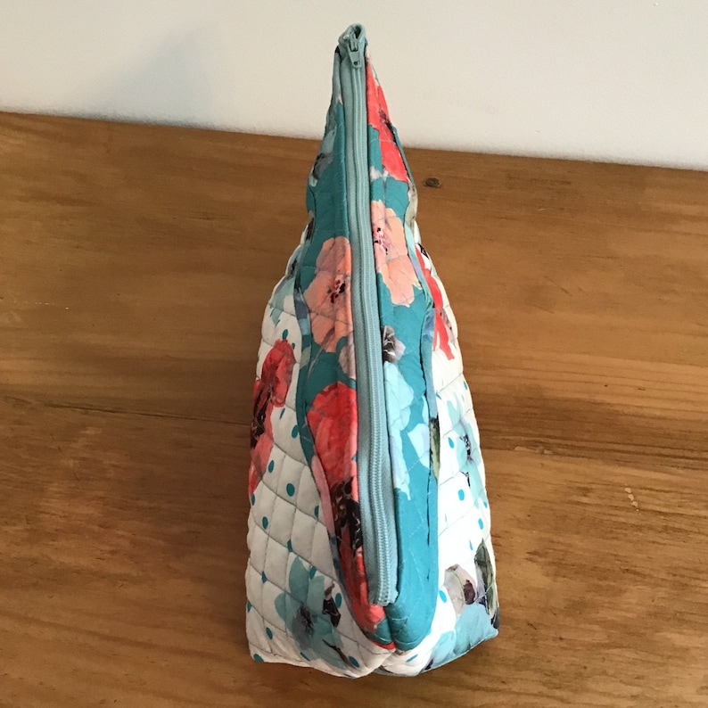Quilted placemat zipper bag in floral print of teal and orange and exterior scalloped edge