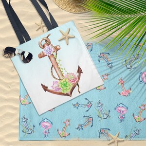 Peut inclure: Un sac fourre-tout blanc avec une ancre brune d&eacute;cor&eacute;e de succulentes roses et vertes. L'ancre est entour&eacute;e d'une corde et d'une &eacute;toile de mer. Le sac fourre-tout est sur une plage de sable avec une serviette de plage bleue avec un motif r&eacute;p&eacute;t&eacute; d'ancres et de succulentes.