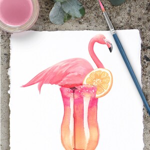 May include: A pink flamingo with a slice of orange perched on top of a tall glass filled with a pink and orange layered drink.