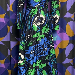 May include: A long-sleeved maxi dress with a floral print in shades of blue, green, and white. The dress has a ruffled hem and a fitted bodice.